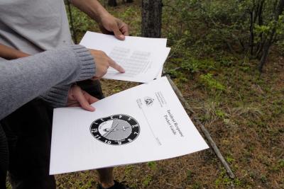 The arms of two people holding Incident Response Pocket Guide documents. One person is pointing at data in a chart.